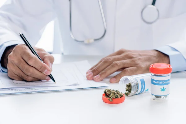 Cropped view of doctor in white coat writing isolated on white — Stock Photo