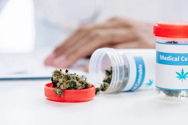 Selective focus of bottle with medical cannabis on white table — Stock Photo