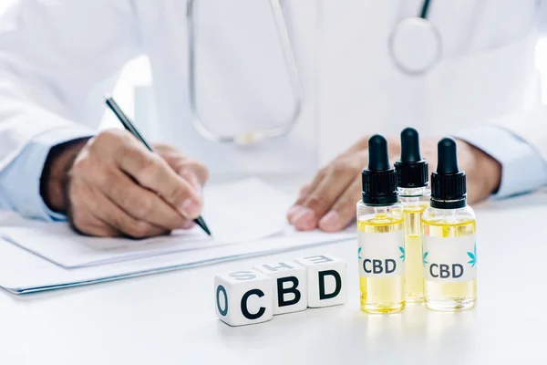Selective focus of cubes and cannabis oil with lettering CBD — Stock Photo