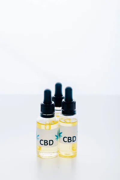 Huile de cannabis en bouteilles avec lettrage cbd sur fond blanc — Photo de stock