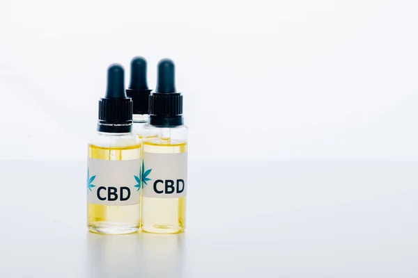 Óleo de cannabis em garrafas com letras cbd sobre fundo branco — Fotografia de Stock