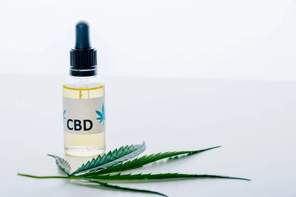 Cannabis oil in bottle with lettering cbd and marijuana on white background — Stock Photo
