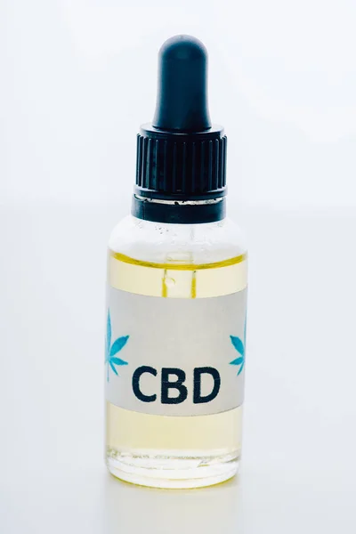 Aceite de cannabis en botella con letras cbd sobre fondo blanco - foto de stock