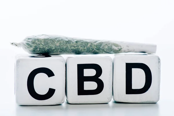 Cubos con letras cbd y contundente sobre fondo blanco - foto de stock