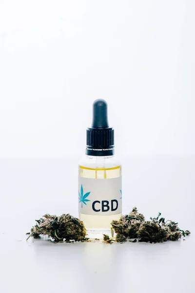 Óleo de cannabis em garrafa com letras cbd e cannabis medicinal sobre fundo branco — Fotografia de Stock