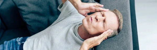 Panoramic shot of handsome man with headache in apartment — Stock Photo