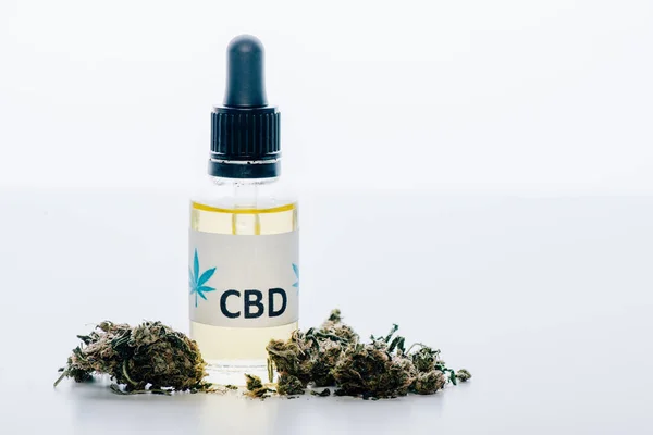 Aceite de cannabis en botella con letras cbd y cannabis medicinal sobre fondo blanco - foto de stock