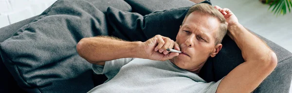 Panoramic shot of man smoking blunt with medical cannabis — Stock Photo