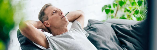 Panoramic shot of man smoking blunt with medical cannabis — Stock Photo