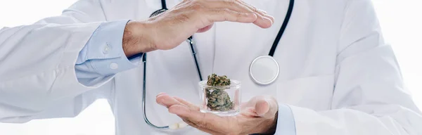 Panoramic shot of doctor in white coat holding medical cannabis and pills isolated on white — Stock Photo