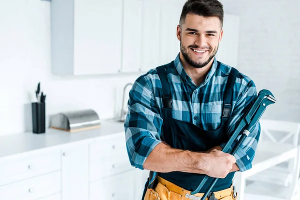 Glücklicher Heimwerker in Uniform stehend und Drahtschneider haltend — Stockfoto