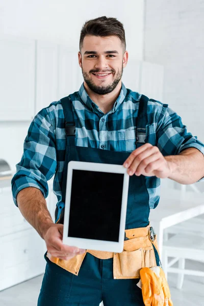 Selektiver Fokus des glücklichen Heimwerkers, der ein digitales Tablet mit leerem Bildschirm hält — Stockfoto