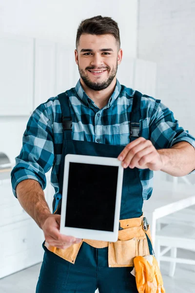 Foco seletivo de feliz faz-tudo segurando tablet digital com tela em branco — Fotografia de Stock