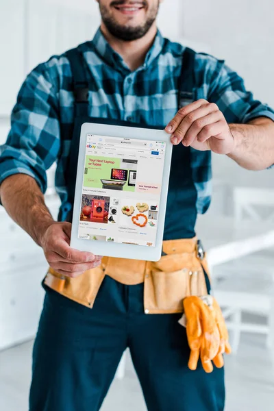 KYIV, UKRAINE - JULY 31, 2019: cropped view of handyman holding digital tablet with ebay app on screen — Stock Photo