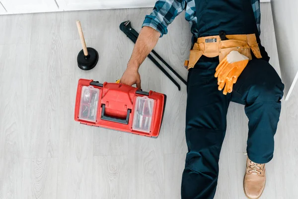 Ansicht der Reparatur, die auf dem Boden liegt und in der Nähe des Werkzeugkastens arbeitet — Stockfoto