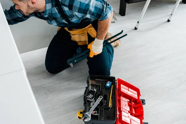 Vue aérienne de l'homme barbu travaillant dans la cuisine près de la boîte à outils avec des instruments — Photo de stock