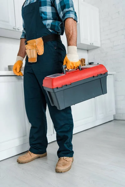 Vista cortada do reparador em pé uniforme e segurando caixa de ferramentas — Fotografia de Stock