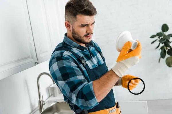 Bel homme barbu regardant entonnoir dans la cuisine — Photo de stock