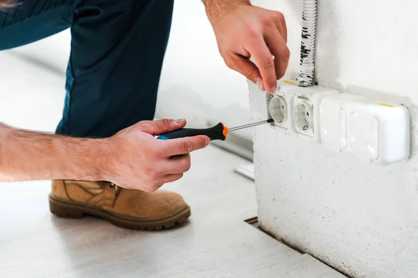 Vista recortada del reparador sentado mientras fija la potencia - foto de stock