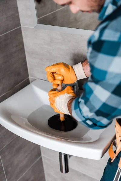 Вибірковий фокус майстра, який тримає плунжер у раковині з водою — Stock Photo