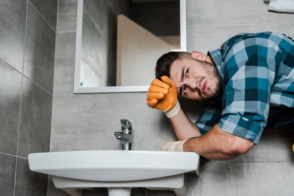 Handsome bearded repairman standing near sink in bathroom — Stock Photo
