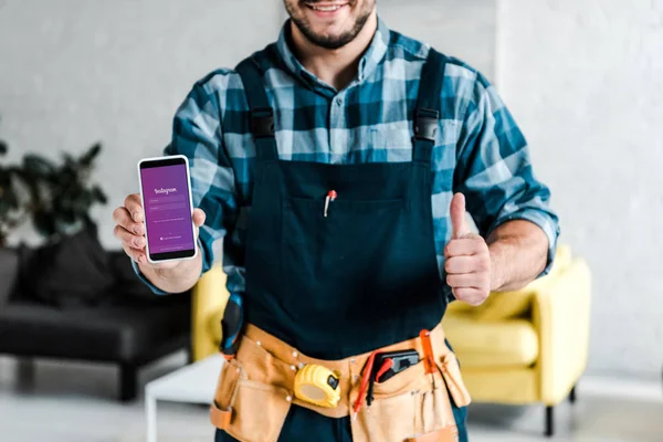 KYIV, UKRAINE - JULHO 31, 2019: visão recortada do homem feliz segurando smartphone com aplicativo instagram na tela e mostrando o polegar para cima — Fotografia de Stock