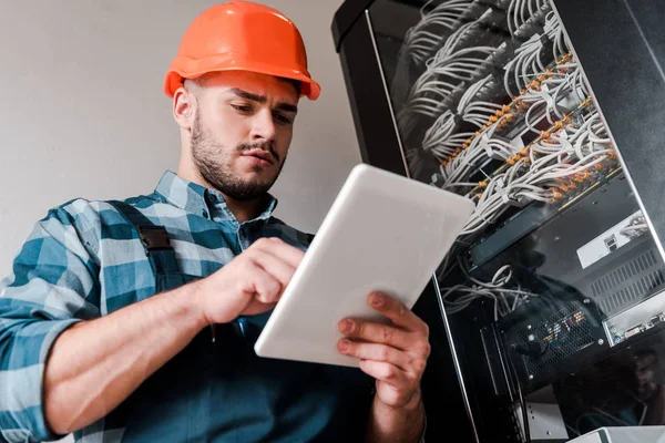 Tiefansicht eines gutaussehenden bärtigen Technikers mit digitalem Tablet — Stockfoto