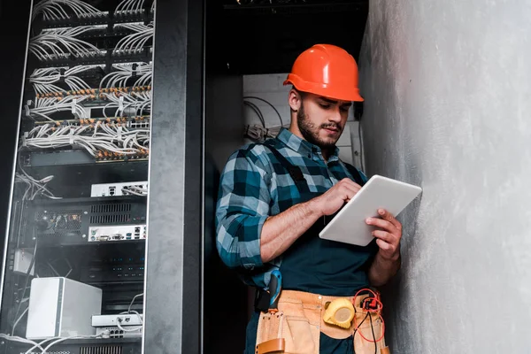 Bel tecnico barbuto in casco di sicurezza con tablet digitale — Foto stock