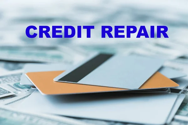 Foco seletivo de pilha com cartões de crédito perto de letras de reparação de crédito em notas de dólar — Fotografia de Stock
