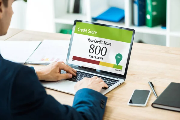 Foyer sélectif de l'homme tapant sur ordinateur portable avec votre pointage de crédit lettrage près du smartphone avec écran blanc sur la table — Photo de stock