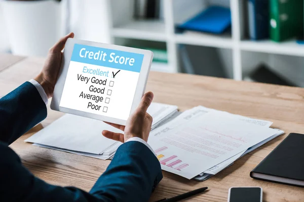Cropped view of man holding digital tablet with speed meters and lettering near charts and graphs — Stock Photo