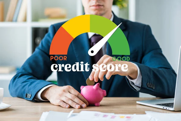 Cropped view of businessman putting metallic coin into piggy bank near speed meter and credit score letters — Stock Photo