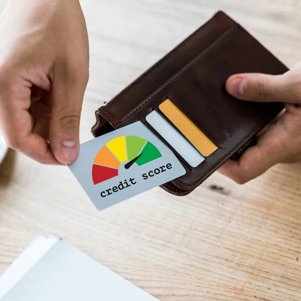 Visão cortada de empresário tomando cartão de crédito com letras de pontuação de crédito enquanto segurando carteira preta — Fotografia de Stock