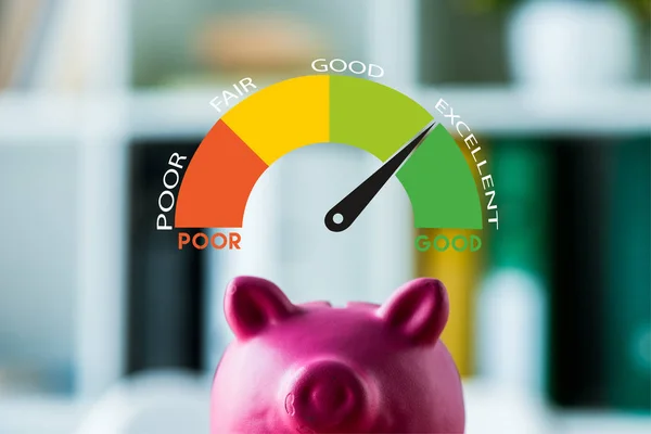 Pink piggy bank on wooden desk near colorful speed meter with letters in office — Stock Photo