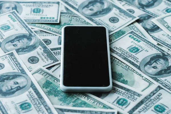 Селективный фокус смартфона с чистым экраном на банкнотах доллара — стоковое фото