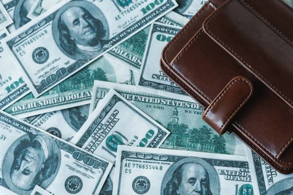 Vue du dessus du portefeuille en cuir marron sur les billets en dollars — Photo de stock