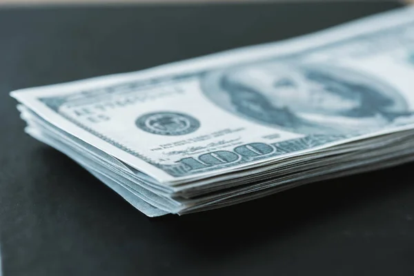 Вибірковий фокус стопки з доларовими банкнотами на чорному — Stock Photo