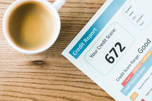 Top view of cup with coffee near paper with credit report lettering on paper — Stock Photo