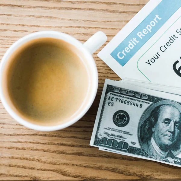 Top view of cup with coffee near paper with credit report lettering on paper and money — Stock Photo