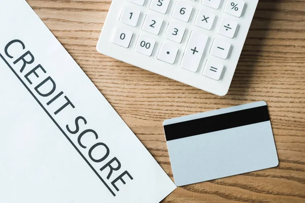 Draufsicht auf kreditkartennahes Papier mit Credit Score Schriftzug und Taschenrechner — Stockfoto