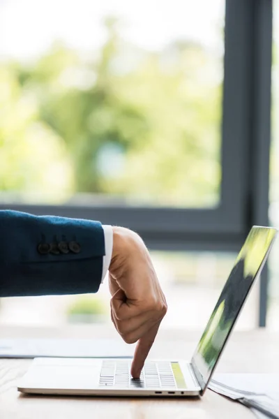 Vue recadrée de l'homme d'affaires pointant avec le doigt au clavier de l'ordinateur portable — Photo de stock