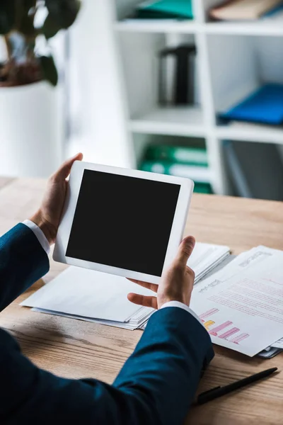 Vista recortada del hombre sosteniendo tableta digital con pantalla en blanco cerca de gráficos y gráficos - foto de stock