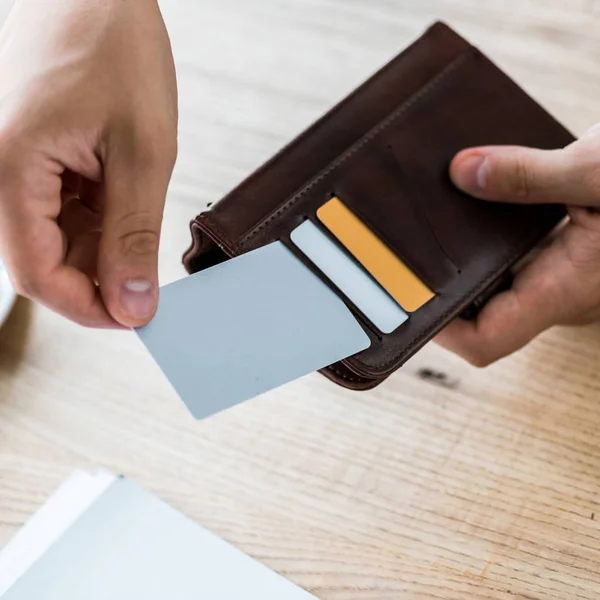 Abgeschnittene Ansicht des Geschäftsmannes, der Kreditkarte nimmt, während er schwarze Brieftasche hält — Stockfoto