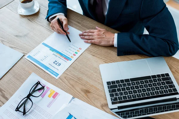 Vista aérea del hombre de negocios en traje que sostiene la pluma cerca del documento con letras y gafas — Stock Photo