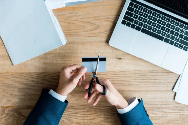 Top view of man cutting credit card with scissors — Stock Photo