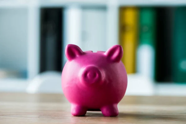 Toy piggy bank on wooden desk in office — Stock Photo
