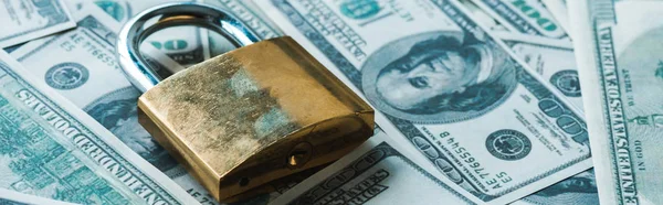 Панорамний знімок металевого замка на доларових банкнотах — стокове фото