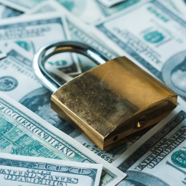 Close up of metallic padlock on dollar banknotes — Stock Photo