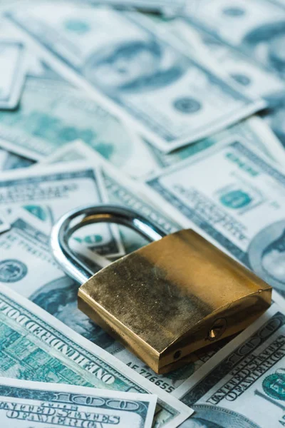 Close up of safety padlock on dollar banknotes — Stock Photo