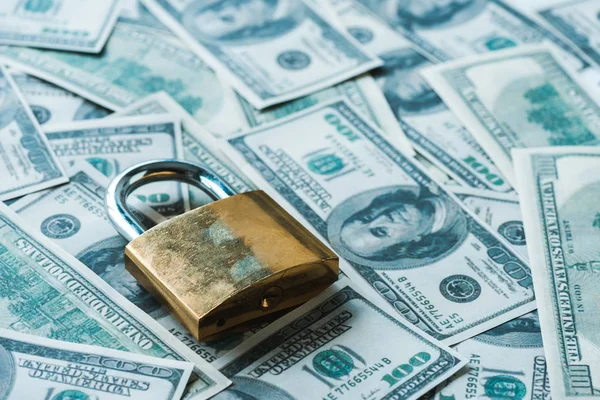 Selective focus of metallic padlock on dollar banknotes — Stock Photo